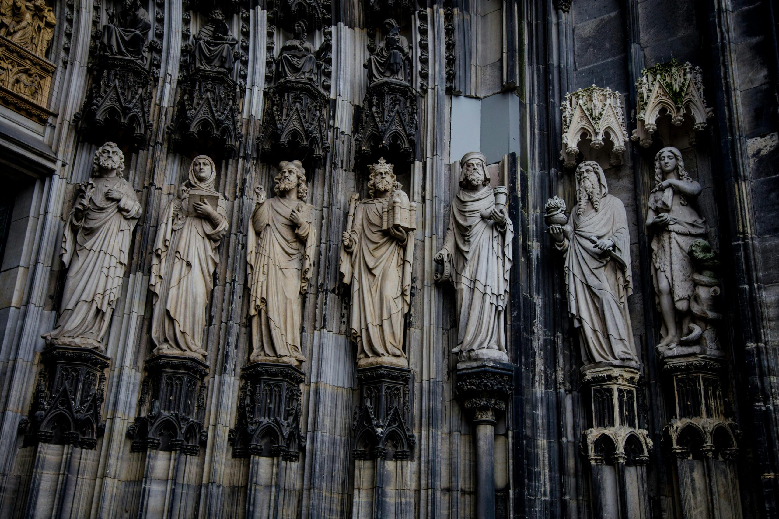 Detailed view of Gothic sculptures adorning the facade of Cologne Cathedral in Germany.